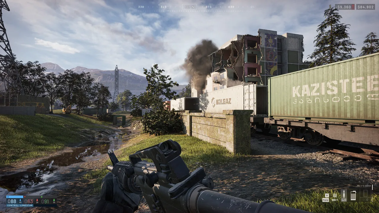 A first-person view across a container yard with a tall tower and smoke in the distance.